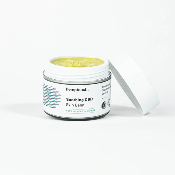 Un pot de Hemptouch onguent au CBD pour la peau irritée (50 ml) sans le couvercle révèle un baume jaune à l'intérieur. L'emballage est blanc, avec des détails et du texte verts.