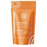 Pochette refermable orange et blanche étiquetée « Good Mood Magnesium Bath Flakes » en anglais et dans une autre langue. Le paquet contient 1 000 g (35,3 oz) de flocons de bain parfumés à l’huile essentielle d’orange douce.