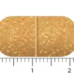 Comprimé rectangulaire tacheté, beige, avec une ligne rainurée mesurant environ 2 cm sur 1 cm de Vitakruid – Multi Jour & Nuit® Femme (2 x 30 comprimés).